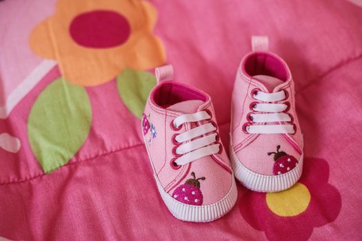 Pink shoes for little baby girl on a blanket