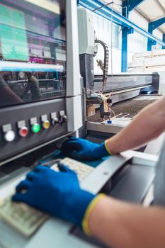 Worker operating a water jet cutting machine by pressing buttons and generally looking good