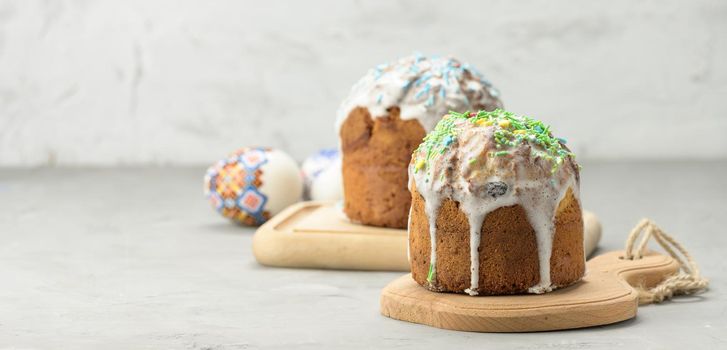 baked traditional Christian dessert for Easter holiday. The pastries are glazed and decorated with multi-colored sprinkles, white backgroundm copy space