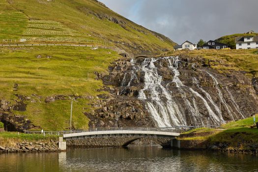 Village and beautiful waterfall landscape of Faroe Islands, Denmark.