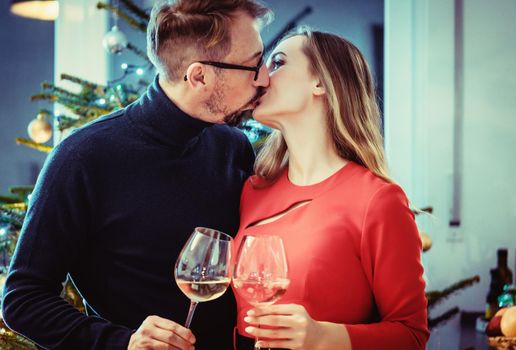 Middle aged couple in romantic pose in front of Christmas tree in seasonal spirit