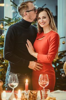 Middle aged couple in romantic pose in front of Christmas tree in seasonal spirit