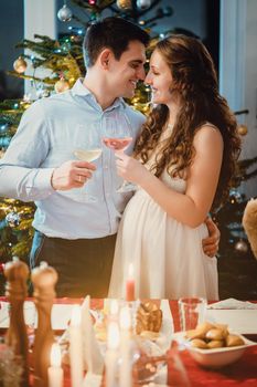 Happy couple celebrating Christmas, the wife is pregnant