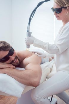 Man under treatment in a hair removal studio