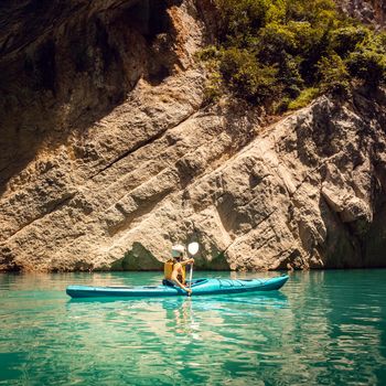 Woman on a kayak in the Pyrenees mountains in Catalonia on the waters of the Mont Rebei Gorge
