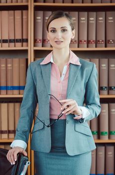 Attorney at law in her office in front of book shelf in the library