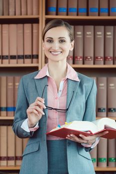 Attorney at law in her office in front of book shelf in the library