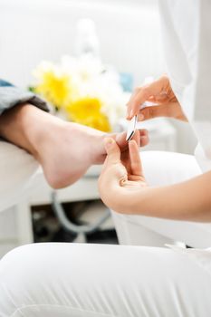 Podiatrist working on men's feet in her parlor