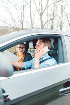 Driving instructor being rather mad at student using his telephone while driving