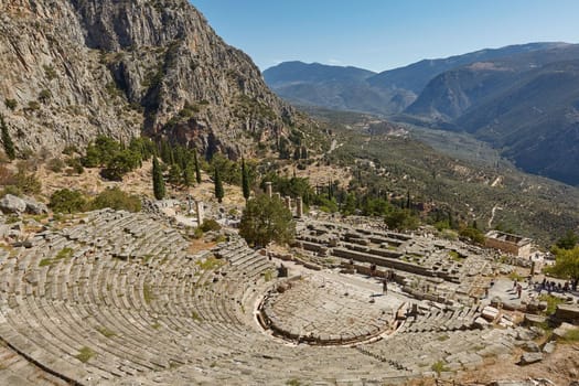Delphi, Phocis / Greece. Ancient Theater of Delphi. The theater, with a total capacity of 5,000 spectators, is located at the sanctuary of Apollo. Panoramic view on a sunny day