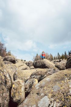 Woman hiking in a wild landscape standing on a rock