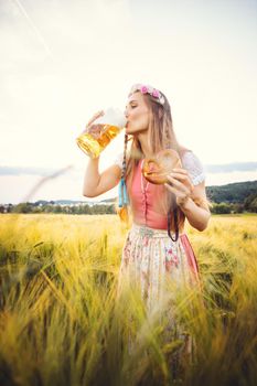 Woman in traditional clothing enjoying drinking beer in Bavaria