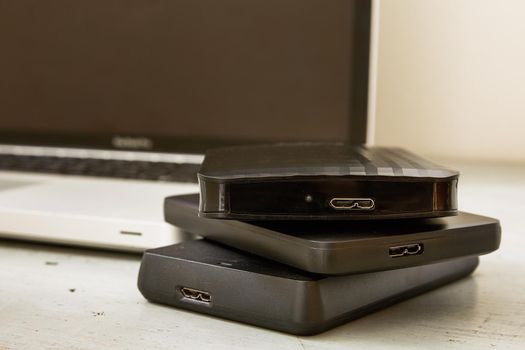 External Hard Disks and Laptop Keyboard on Wooden Table.