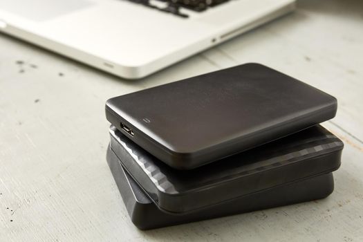 External Hard Disks and Laptop Keyboard on Wooden Table.