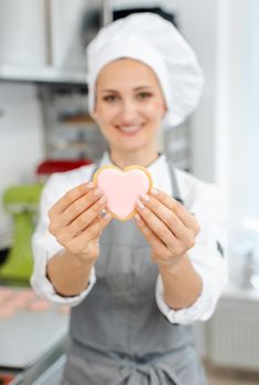 Pastry chef is in love with her trade showing it with heart shaped sweets and cookies