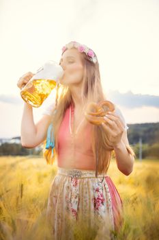Woman in traditional clothing enjoying drinking beer in Bavaria