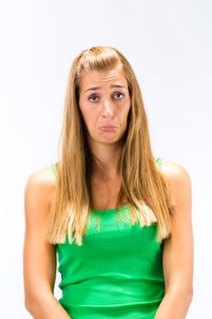 Despair young woman in green tanktop isolated over white background