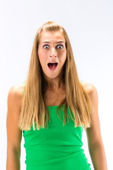 Portrait of excited young woman in green tanktop against white background