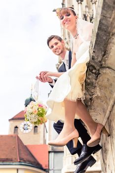 Smiling young married couple holding flower bouquet at outdoors