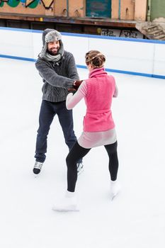 Romantic figure ice skater couple dancing together on ice rink