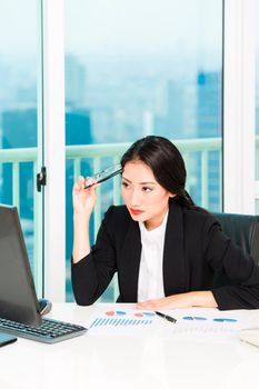 Beautiful young businesswoman looking at computer in the modern office