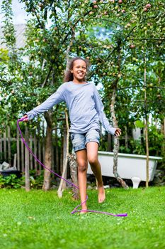 Portrait of a girl skipping in the yard