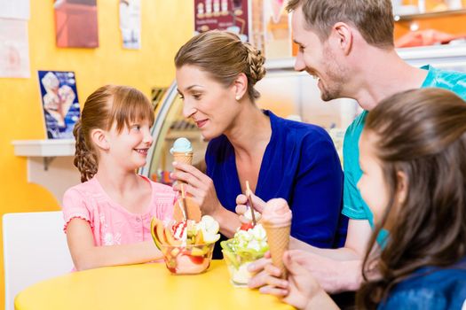 Family in ice cream parlor enjoying a sweet dessert
