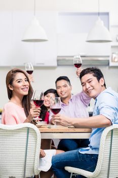 Portrait of young couple enjoying drinks with friends