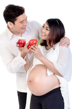 Smiling husband giving fruits and vegetable to his pregnant woman