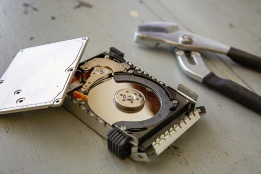 Broken and Destroyed Hard Drive Disk on Wooden Table.