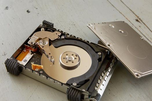 Close Up of Broken and Destroyed Hard Drive Disk on Wooden Table.