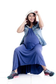 Smiling pregnant woman touching her hat isolated over white background