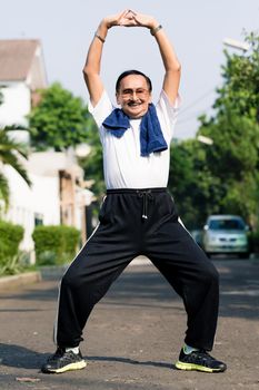 Portrait of senior man exercising on street