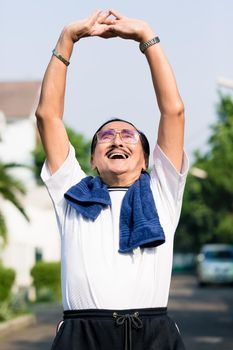 Portrait of happy senior man stretching his hands