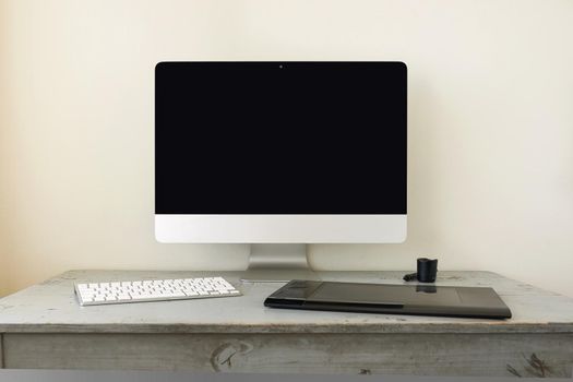 Computer with Keyboard and Graphic Tablet on Wooden Table and Space for Copy.