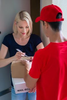 Women is signing a device receiving packages from the delivery person
