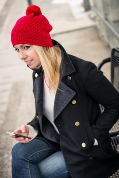 Woman using her phone while waiting for a suburban train