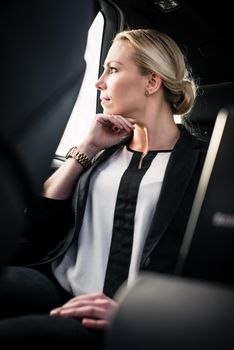 Portrait of stylish young businesswoman sitting in car