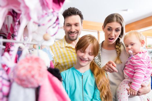 Portrait of happy family shopping in the clothes store