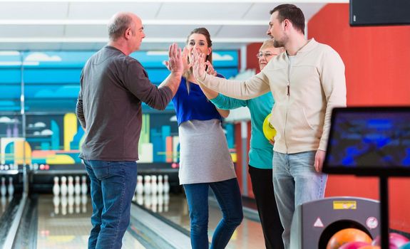 Smiling family enjoying indoor games giving high-five