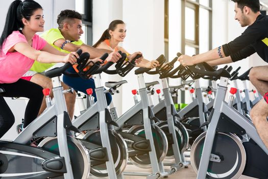 People cycling in row at gym