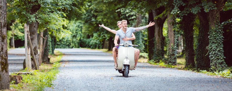 Happy young couple enjoying on old-fashioned scooter