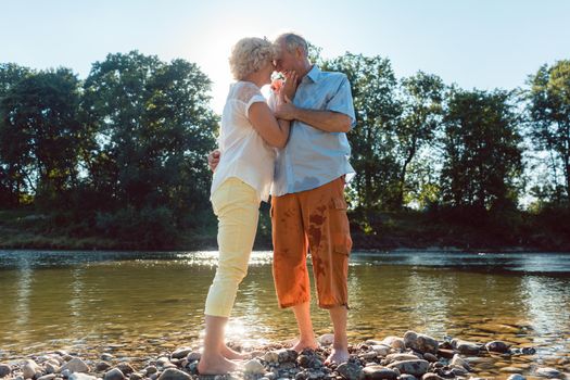 Low-angle side view portrait of a romantic senior couple in love enjoying a healthy and active lifestyle outdoors in summer