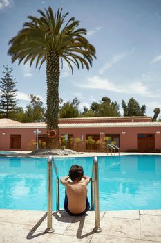 Young Boy Enjoying Vacation at Tropical Swimming Pool in Arequipa, Peru.