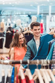 Happy couple shopping for fashion items in high end boutique