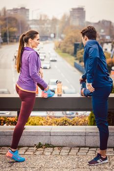 Athletic couple exercising for better fitness in a modern city