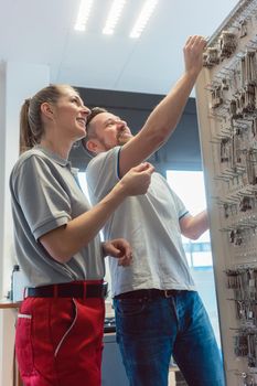 Man and woman key maker in their shop choosing blanks