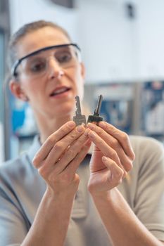 Woman at key cutter shop looking at blanks comparing them