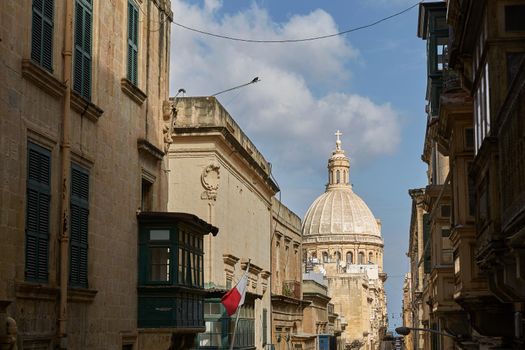 Traditional narrow street and church in Valletta in Malta.