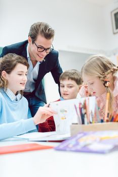 Teacher and students working together in a group or team session being absorbed in their work